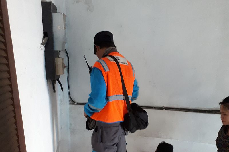 Handen van een elektricien tijdens het aansluiten van een meterkast.