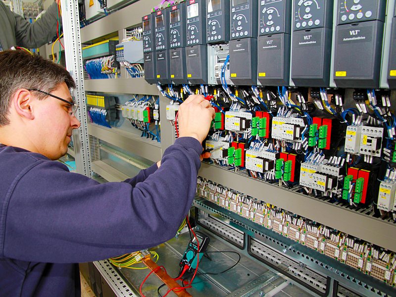 Monteur werkt aan de bedrading van een elektrische schakelkast.